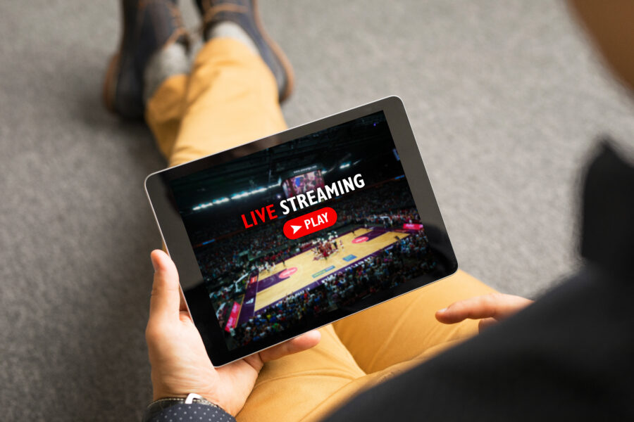 Man watching sports on live streaming online service—avoid geo-blocking when watching your favorite sports