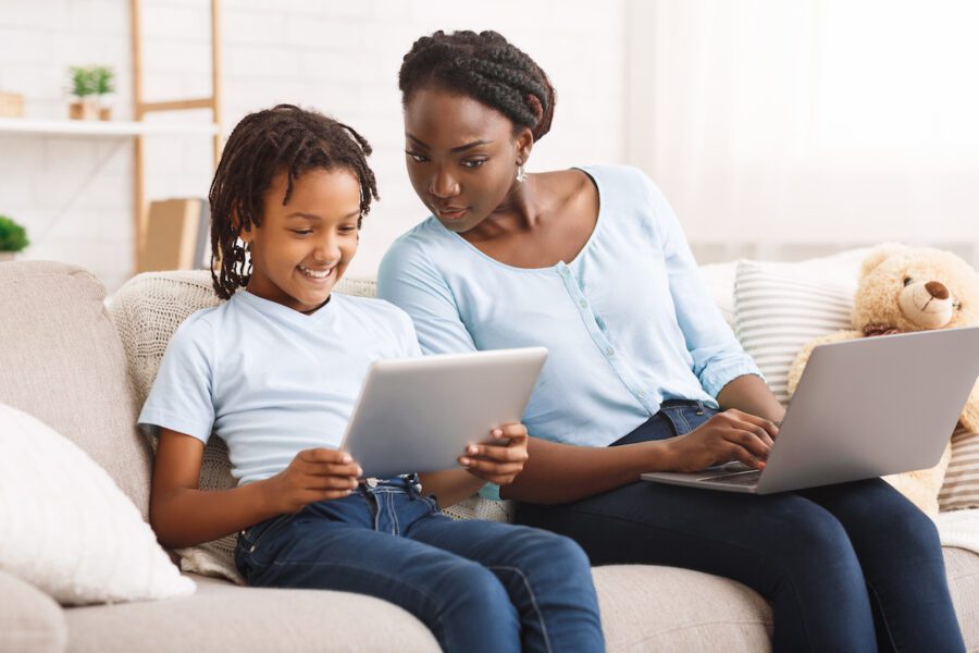 Parental Control & Online Safety. Black mother watching her daughter's activity online.